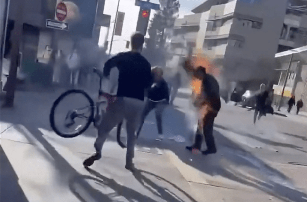 趴下较易灭火但该名男子拒绝，途人试图用单车将他撞低。