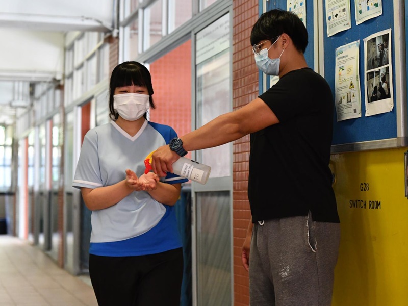 出入課室有學校職員為學生提供消毒搓手液。