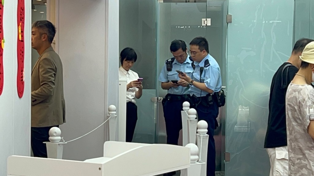 警員在找換店調查。 警員在找換店調查。