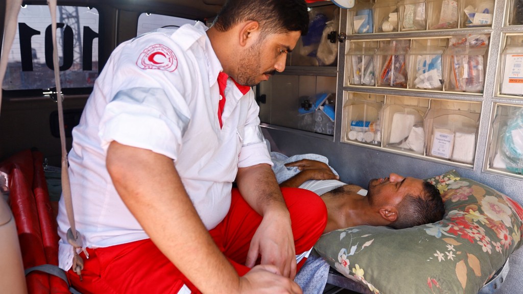 医护人员与准备送往埃及治疗的伤者对话。 路透社