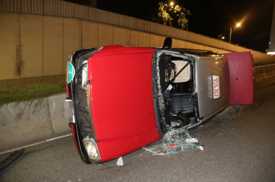 的士為避車撞到路中分隔石壆，迅即翻側，倒在路中。黎志偉攝