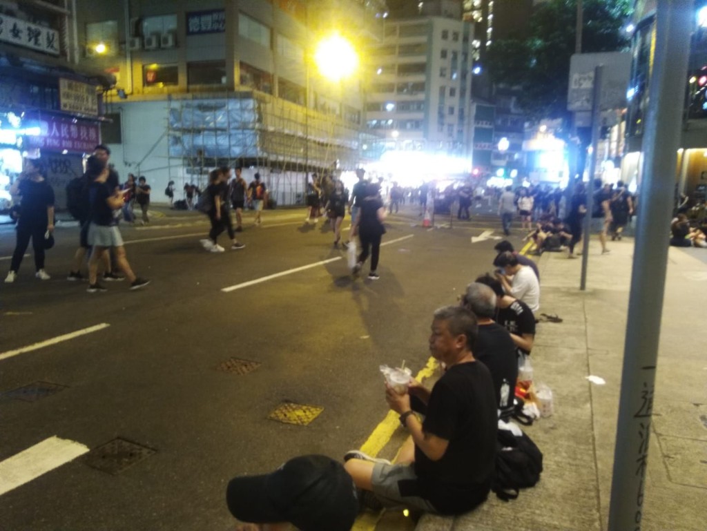 不少市民在主要遊行路綫的附近席地而坐。