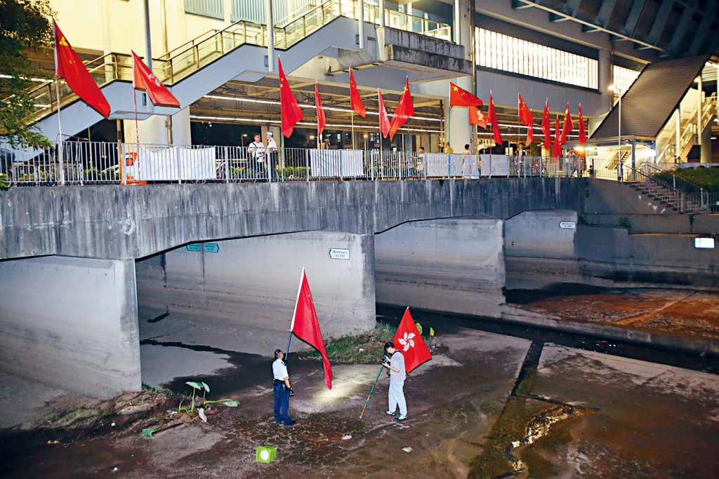 警員到場拾起國旗和區旗。