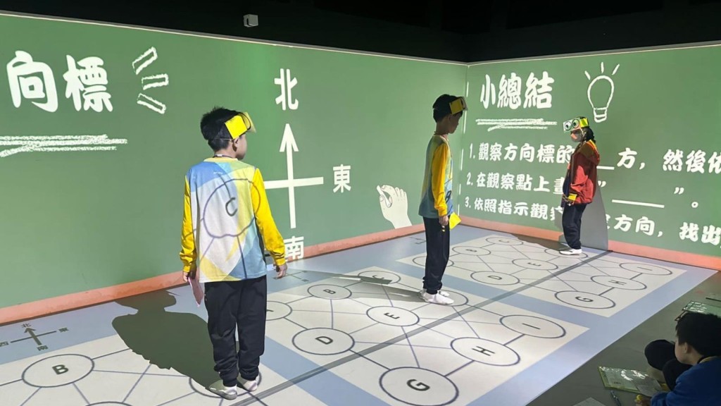 學生透過地面投影的大型棋盤，進行方向探索活動。受訪者提供