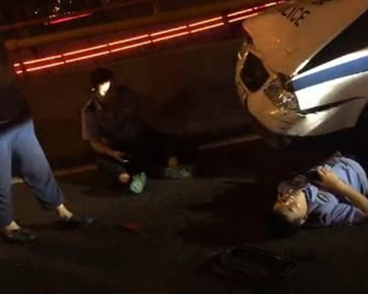 其中两名受伤警员在地上等待救援。网图