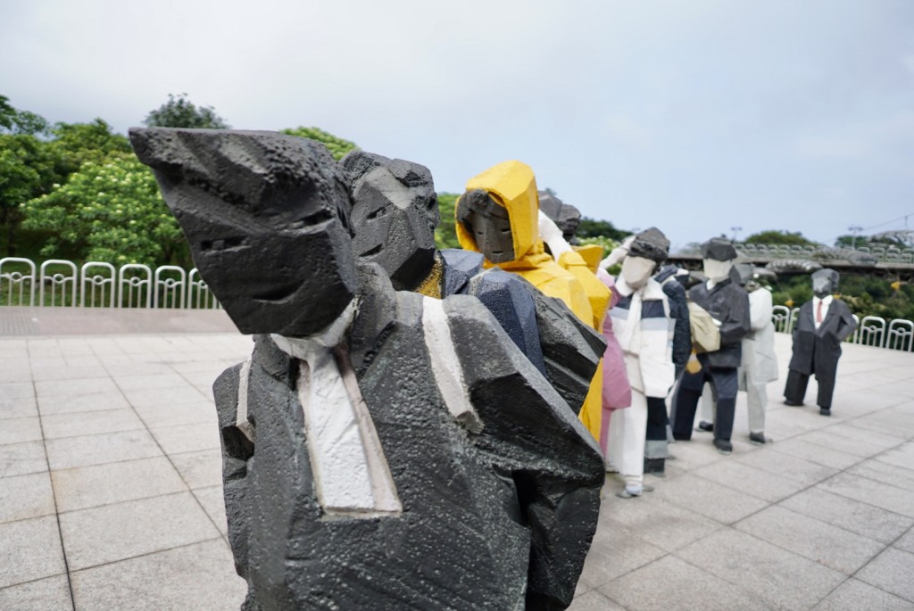 設在美術館本館門口前的一組雕塑作品，是叫港人親切的《人間系列——排隊》。