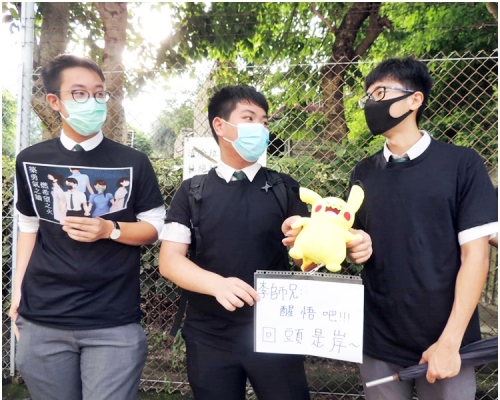 中六生陳同學手持標語及「比卡超」公仔,諷刺師兄保安局局長李家超。