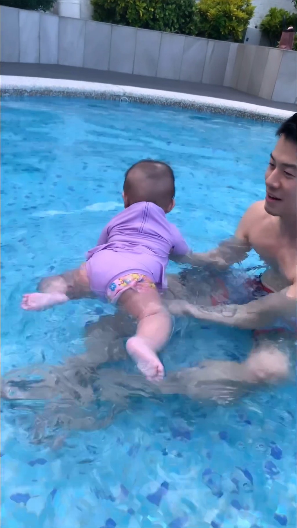 之后陈宇琛将女儿抱在手中，让她浮在水面。