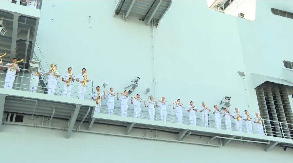 又有軍樂隊於站在艦上高層演奏歌曲。 又有軍樂隊於站在艦上高層演奏歌曲。