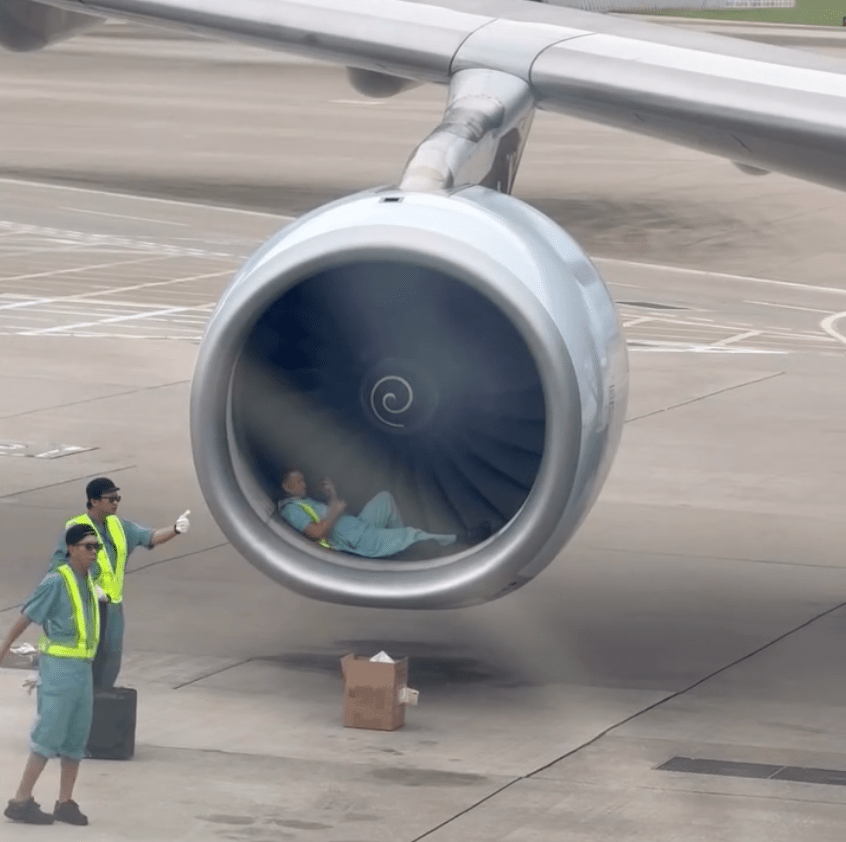 一名機場地勤維修人員躺在飛機引擎前，被指正在小休。Threads @ toto_tongpuiyee 影片截圖
