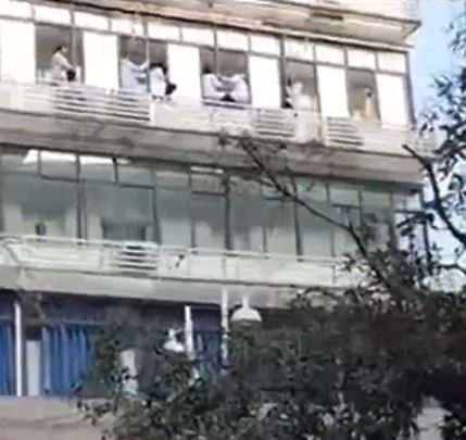 四川遂宁市中医院十多医护危坐窗边维权。影片截图