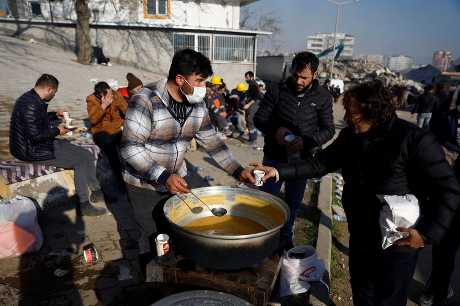 救援人员在土耳其灾区向灾民提供食物。 路透社