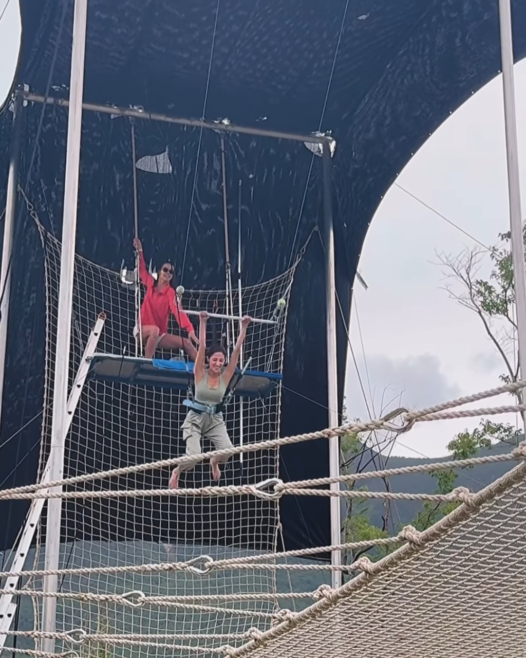 陳凱琳繫上安全帶及威吔後，雙手捉緊玩空中飛人的鞦韆橫桿，然後工作人員將她推出去。