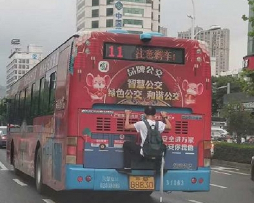 男子趴在巴士車尾。網上圖片