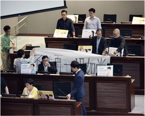 民主派議員為表達不滿,在會議室內站立抗議。
