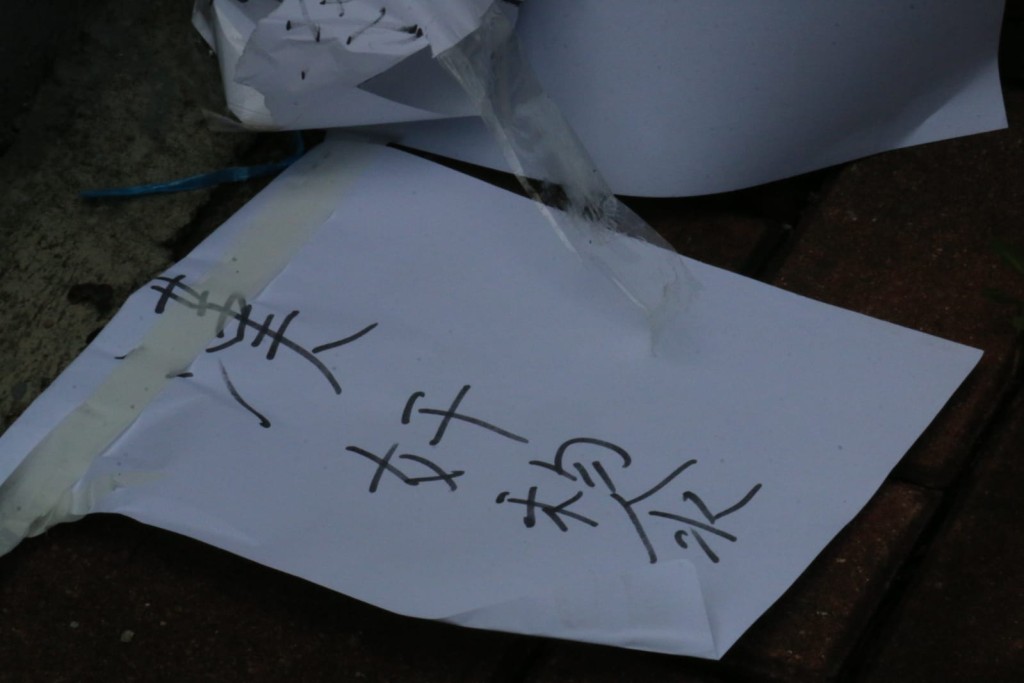電箱上的標語被撕走,棄於垃圾桶旁的行人路上。