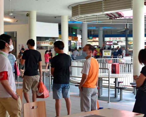 新加坡市民保持距離排隊買飯。AP