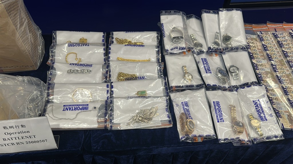 警方展示涉案財物，包括名錶、現金及名酒。