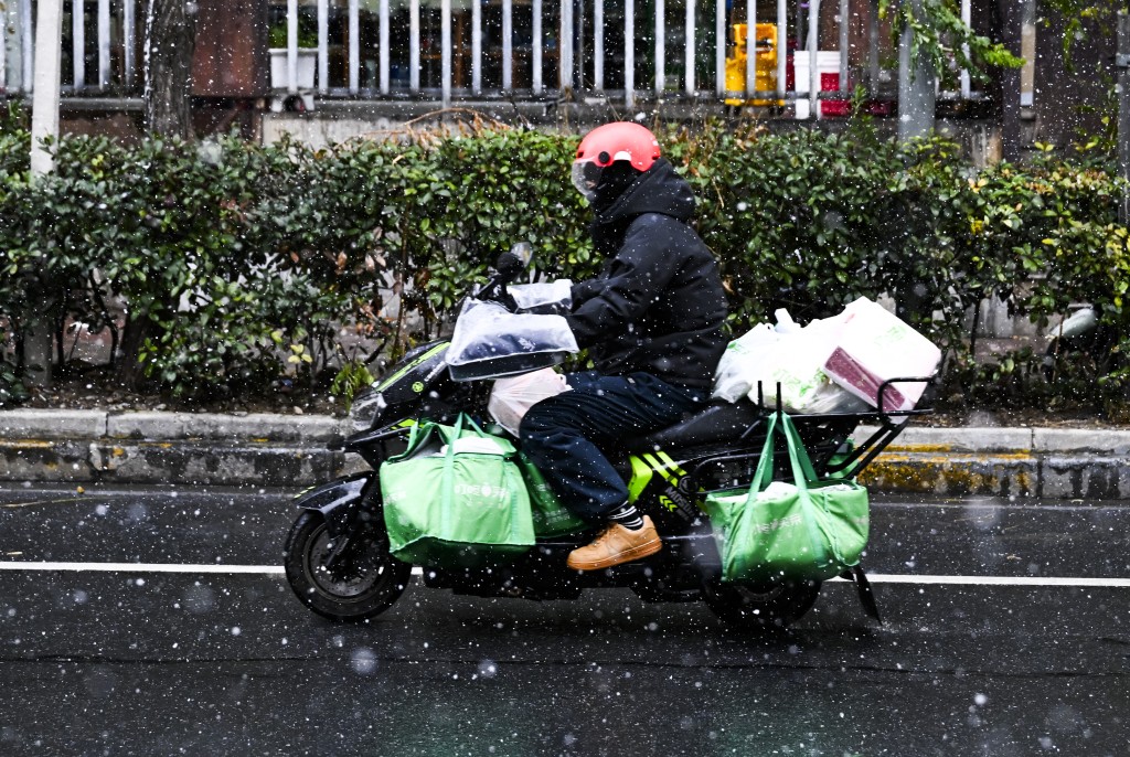 市民在上海市普陀區冒雪騎行。 新華社
