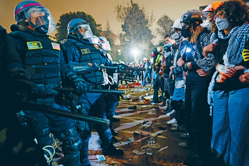 防暴警察周四摧毀UCLA校園內部分營地路障後,與親巴勒斯坦學生對峙。