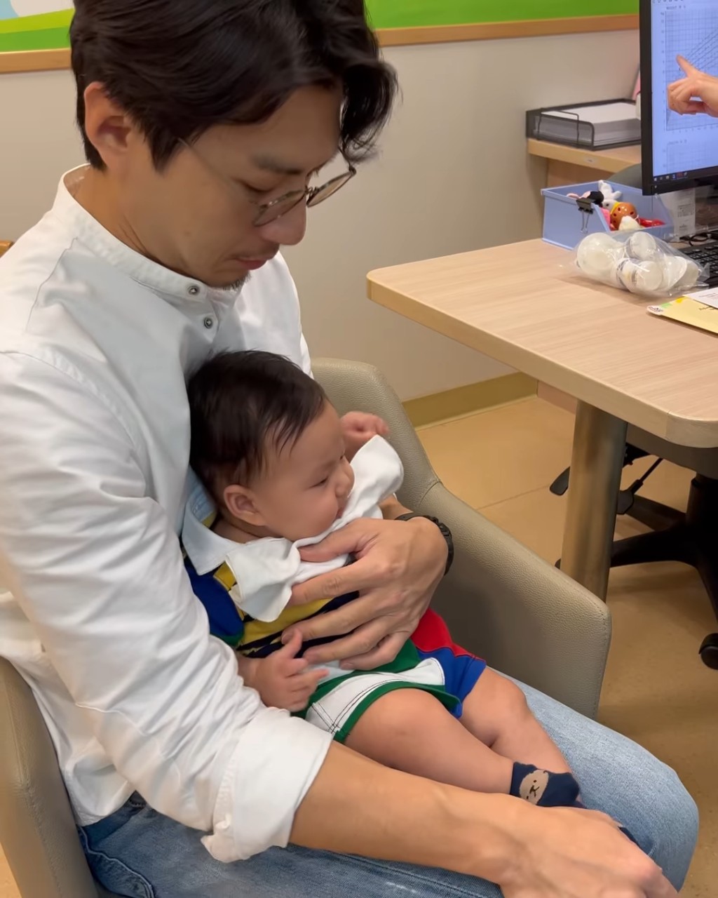 袁伟豪近日带儿子回出生的医院见医生，父子细心聆听医生讲解“袁咕碌”的儿童保健报告。