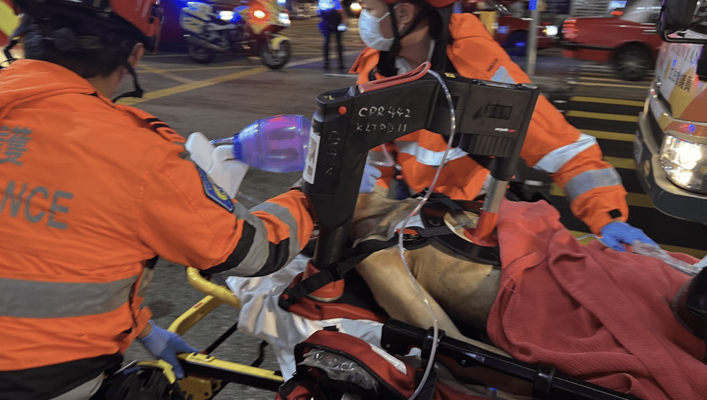 救護人員一邊為男傷者使用自動心肺復甦機,一邊將他緊急送院。黎志偉攝 救護人員一邊為男傷者使用自動心肺復甦機,一邊將他緊急送院。黎志偉攝