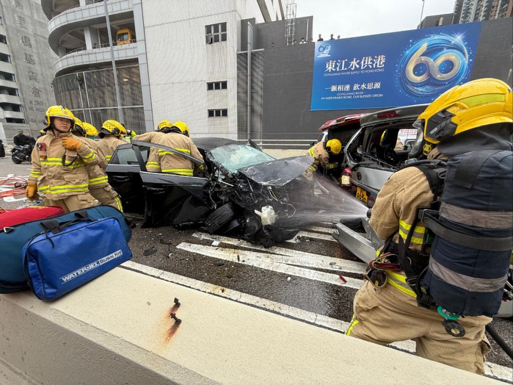 消防向黑色私家車射水降溫。