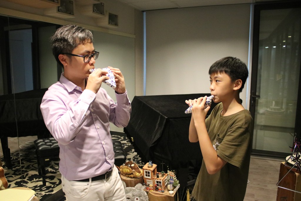 黃耀凱（右）每周隨原樂天（左）上一次一對一 陶笛課堂，另有參與香港兒童陶笛樂團練習。