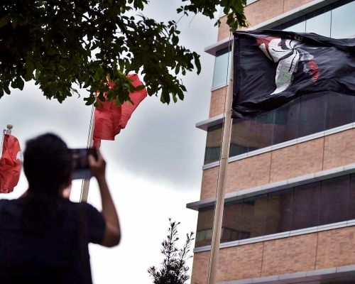 理大學生換上黑旗抗議。