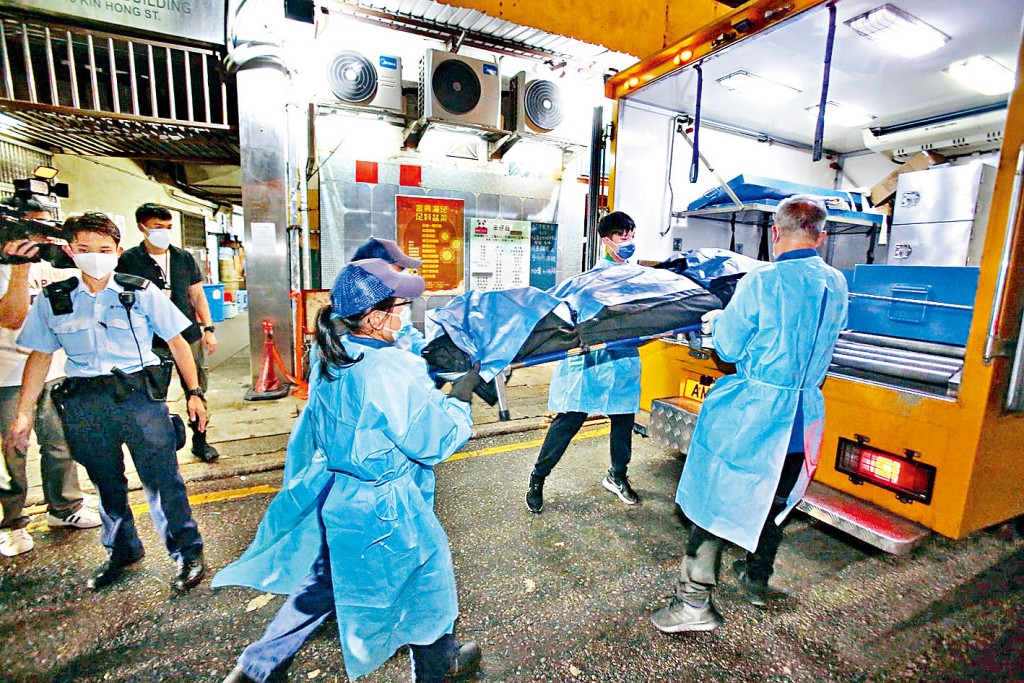 仵工將葵涌工廈旅行袋藏屍案77歲男死者遺體舁上車運往殮房。