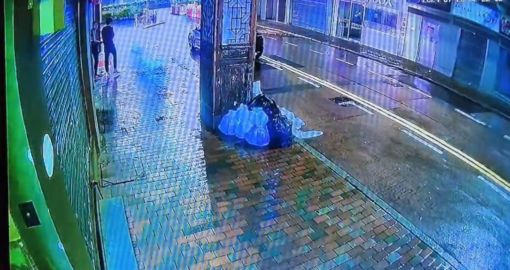 事主離開庇利金街63號唐樓,之後站在街頭,當時他身邊有一名長髮女子。 事主離開庇利金街63號唐樓,之後站在街頭,當時他身邊有一名長髮女子。