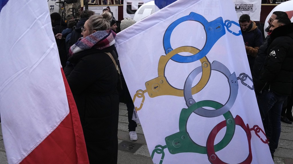 巴黎警察将奥运五环改成手铐，抗议奥运期间开工未必有补假和补偿。 美联社