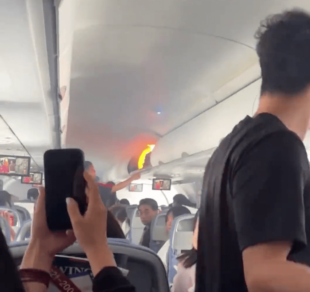 飛機客艙行李架上出現了明火。 飛機客艙行李架上出現了明火。