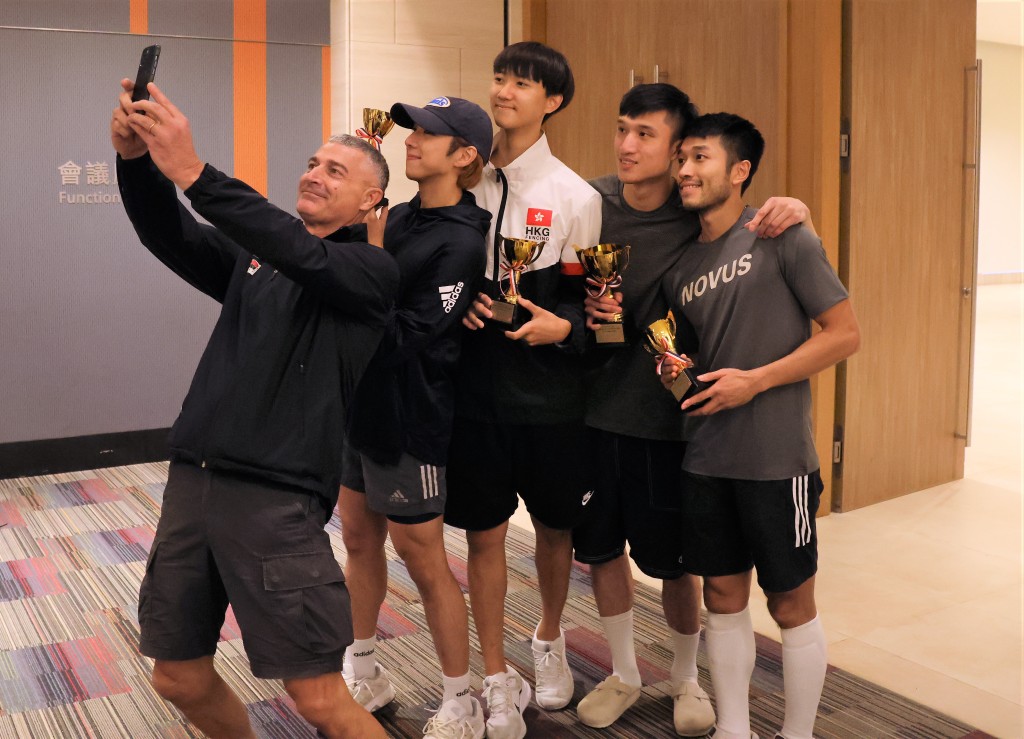 港队教练（左至右）与崔浩然、梁千雨、蔡俊彦及柯俊而玩大合照。 本报记者摄