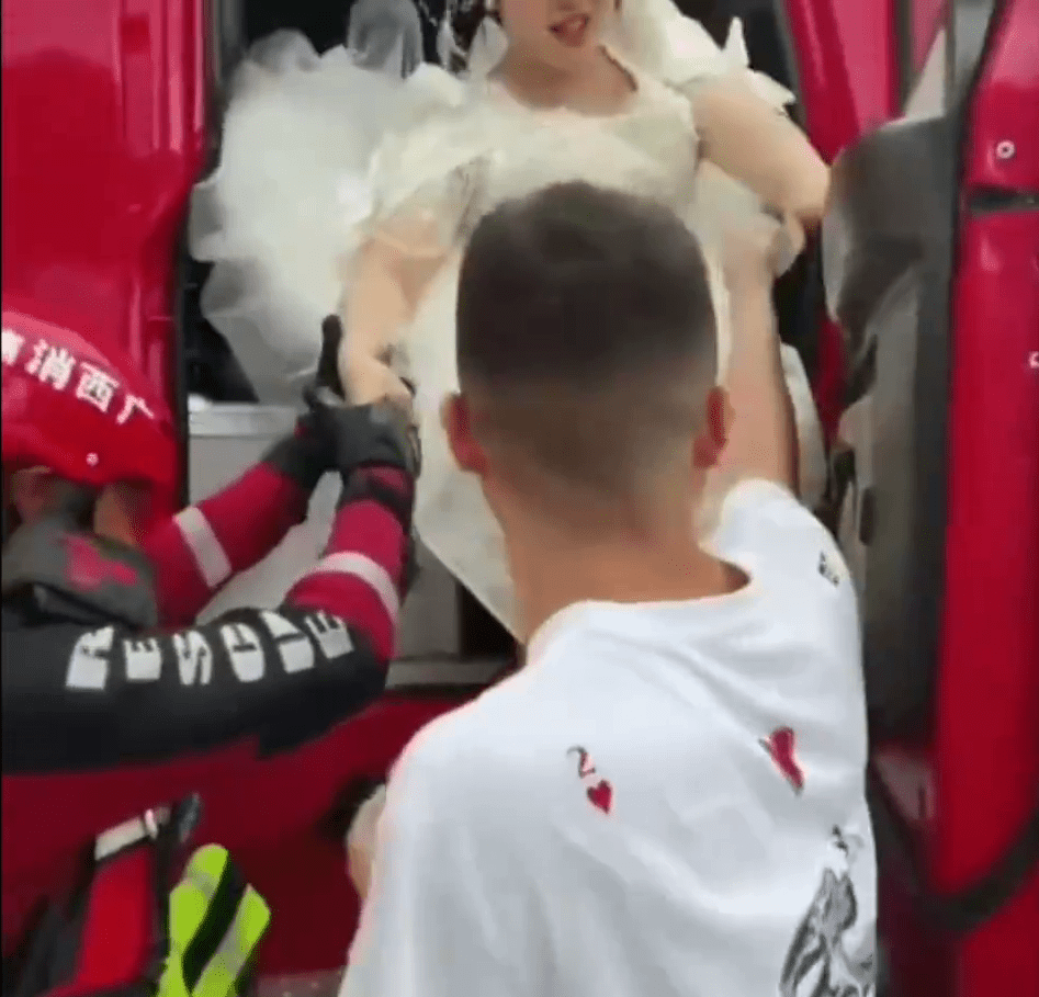 新娘在消防员的协助下缓缓下车。