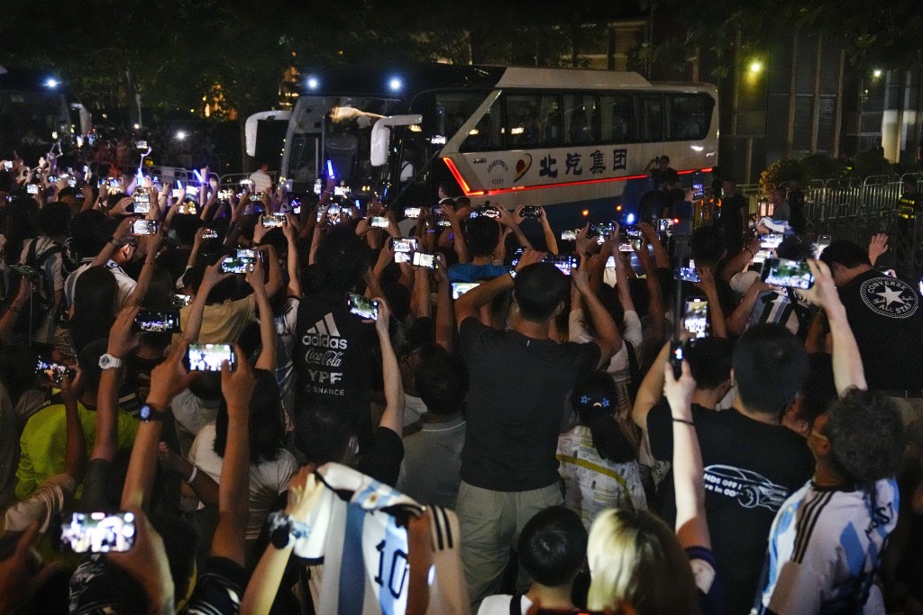 中國球迷舉起手機對身在旅遊巴上的美斯狂拍。AP
