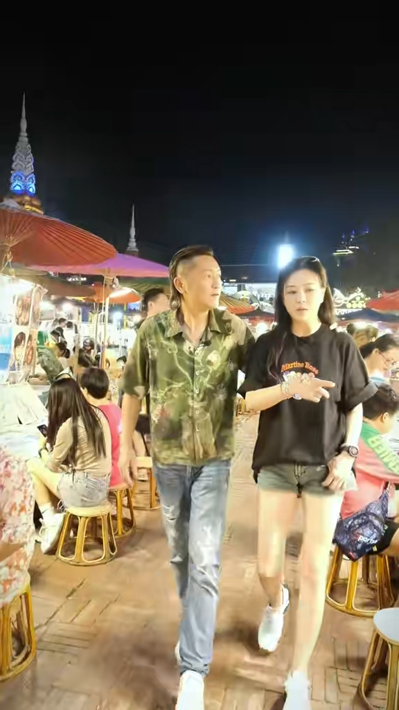 穿上黑Tee热裤的刘小慧孖老公苏志威到云南西双版纳游夜市觅食，一双修长白滑的光管美腿，非常抢fo。