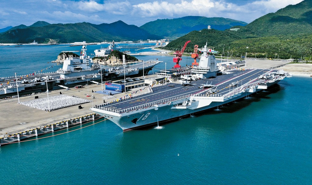 海南三亞軍港內，福建艦踏海而立、滿旗高懸，正式入列。左為山東艦。