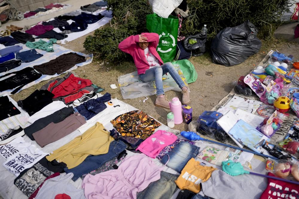 在阿根廷布宜諾斯艾利斯郊區，一個小販在街邊售賣二手服裝。AP
