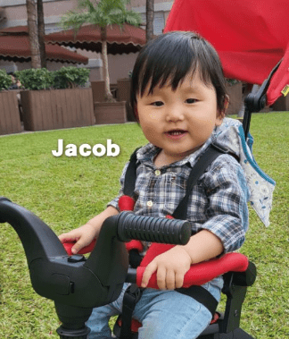 Jacob仔快一歲，正健康的成長，笑容滿面踏着嬰兒單車。