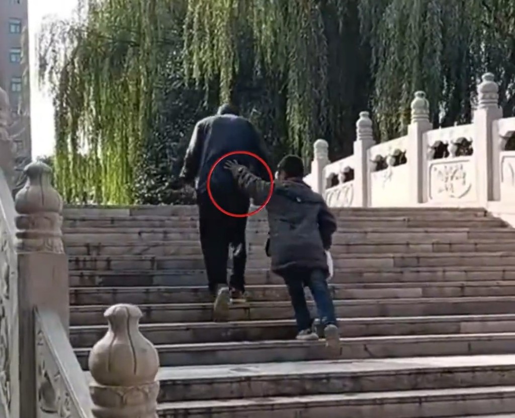 同行男孩不斷推著老翁。
