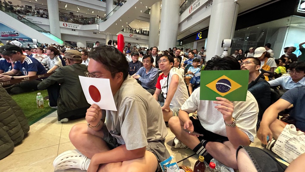 有球迷手持兩隊球隊國旗支持。