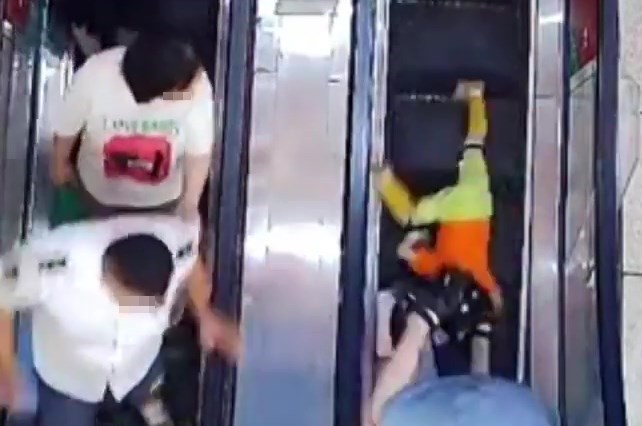 左旁乘扶手电梯落楼的一对白衣男女目击事件后，到地后立即冲上前帮忙。网上截图
