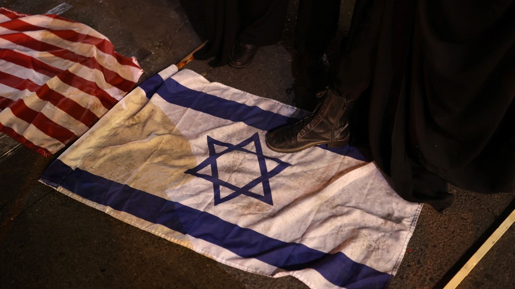 伊朗示威者在示威中践踏地上的以色列旗。 路透社