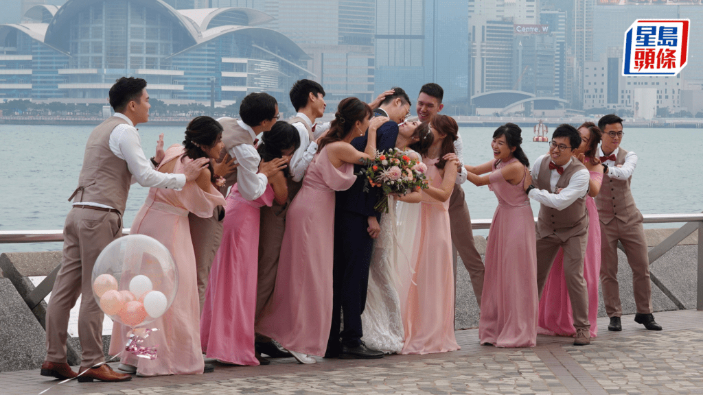 新人和伴郎伴娘在香港尖沙咀海濱拍攝婚紗照。 中新社資料圖