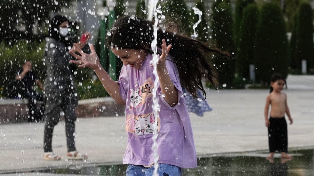 德黑兰周二录得摄氏38度，小朋友在易卜拉欣公园的喷泉玩水消暑。 美联社