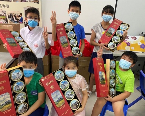 明愛「青少年及社區服務」的受惠學童接過中秋禮盒。順豐圖片