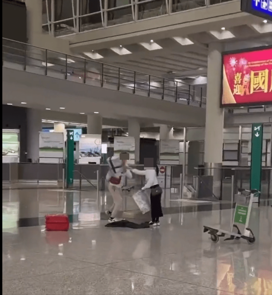 男子突然奪過女方的一件行李。影片截圖