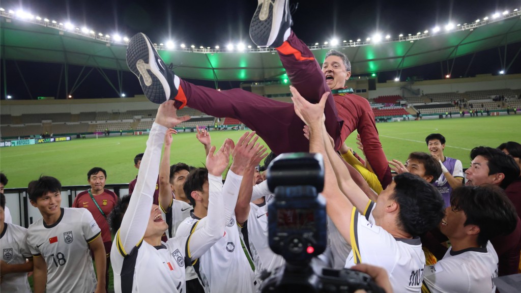 中國隊球員3比0完勝越南後拋起主教練安東尼奧·普切（上）慶祝。新華社