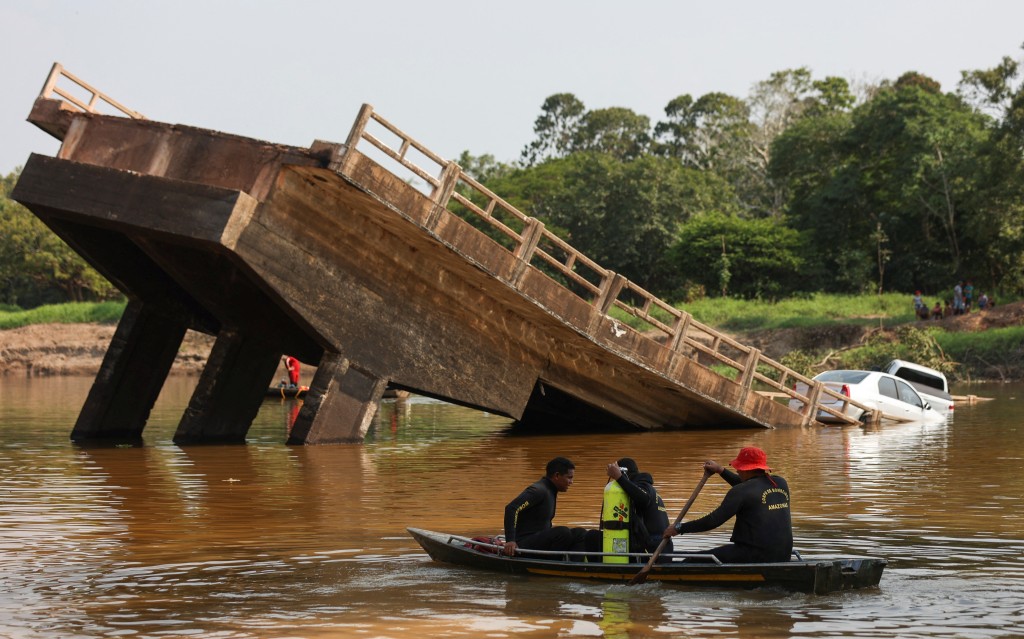 橋倒塌後，救援人員在庫魯卡河上搜救。路透